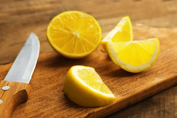 Limones frescos en rodajas sobre fondo de madera — Foto de Stock