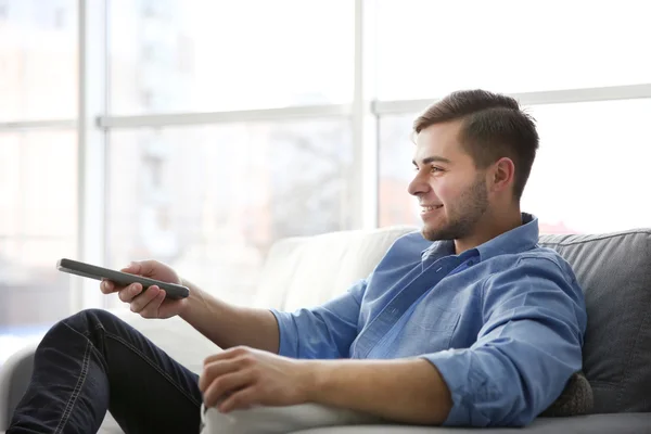 Hombre joven viendo la televisión en casa —  Fotos de Stock