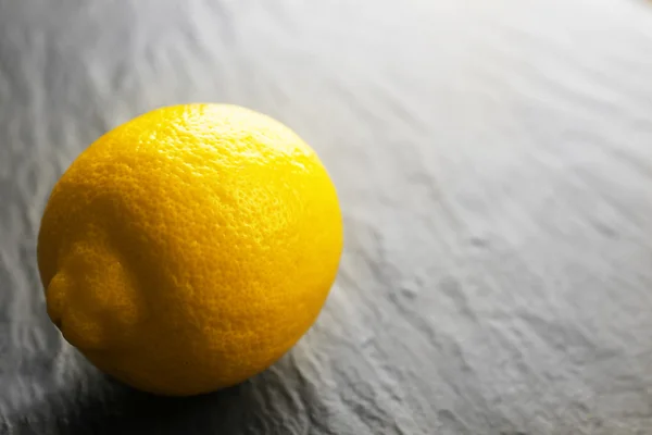 Fresh lemon on black textured background — Stock Photo, Image