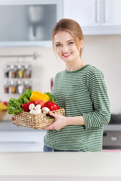 Jeune femme avec panier de légumes — Photo