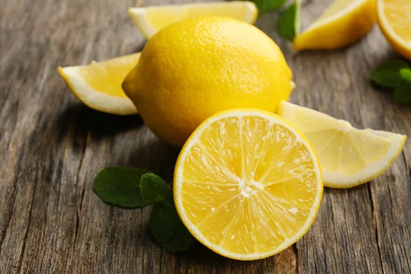 Slices of fresh lemons on wooden background — Stock Photo, Image