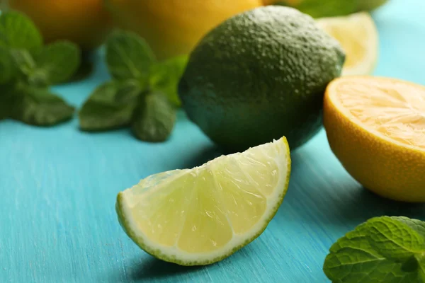 Fresh lime and lemon on blue table closeup — Stock Photo, Image