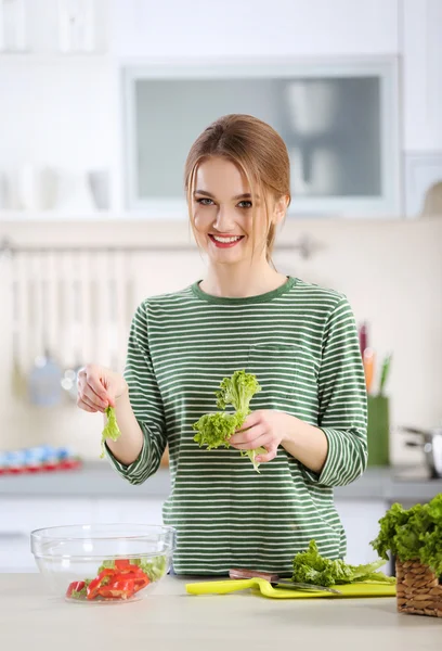 Jovem mulher preparando salada vegetal — Fotografia de Stock