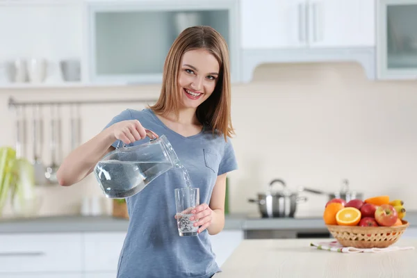 Young woman pouring water — Stock Photo, Image