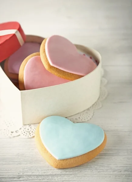 Biscuits coeur Saint Valentin dans la boîte actuelle sur fond en bois — Photo