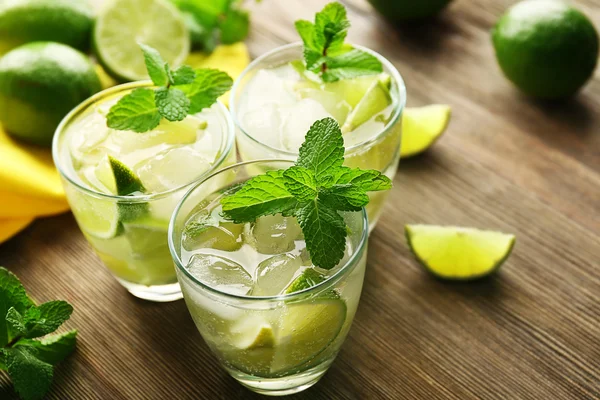 Bebida mojito con lima y menta sobre mesa de madera — Foto de Stock