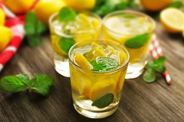 Samenstelling van limonades, citroenen en mint op houten tafel achtergrond, close-up — Stockfoto