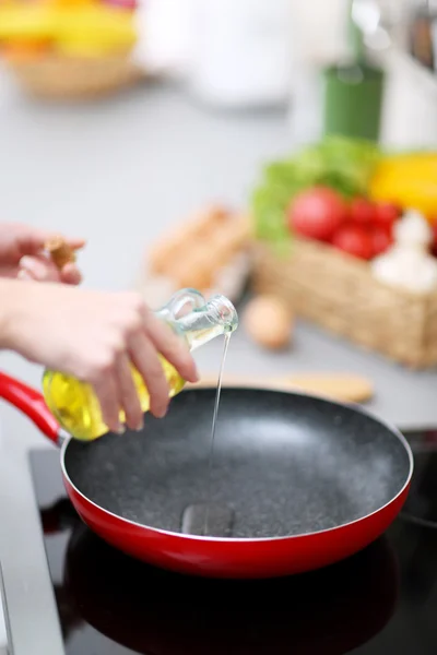Человеческие руки с маслом и сковородкой — стоковое фото