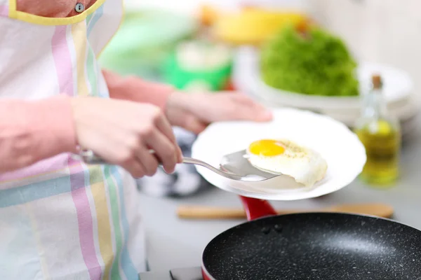 Руки кладут яйца на тарелку — стоковое фото