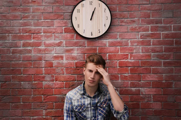 Homem e relógio na parede de tijolo — Fotografia de Stock