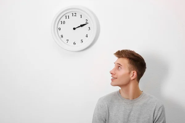 Человек и часы на стене — стоковое фото