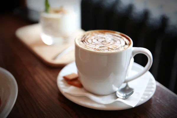 Cup of cappuccino on table in cafe — Stock Photo, Image