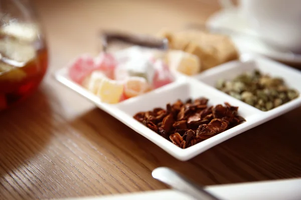 Plaat met verschillende suiker en specerijen op tafel in café of restaurant — Stockfoto
