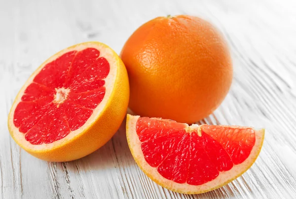 Juicy grapefruits on wooden background — Stock Photo, Image