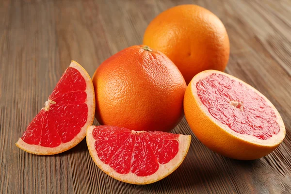 Juicy grapefruits on wooden background — Stock Photo, Image