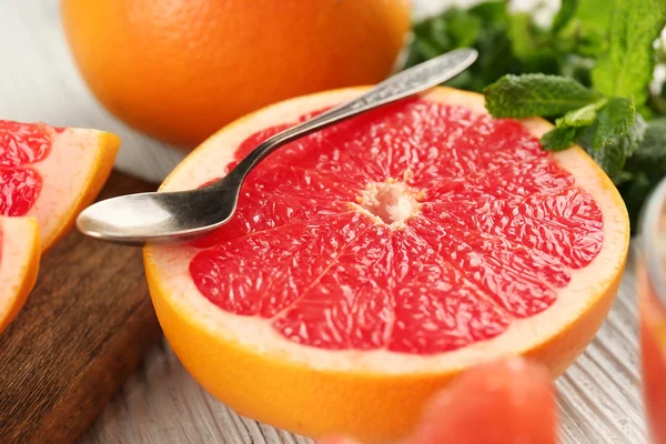 Gesneden grapefruits met munt op houten achtergrond, close-up — Stockfoto