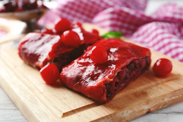 Delicioso strudel de cereza con menta en la tabla de cortar — Foto de Stock