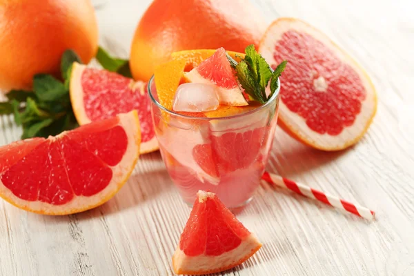 Pompelmi maturi e succo fresco con menta, primo piano — Foto Stock