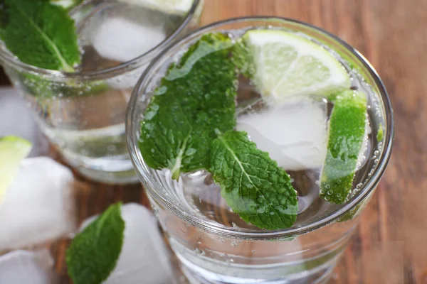 Fresh cocktail with mint, ice and lime on wooden table background — Stock Photo, Image