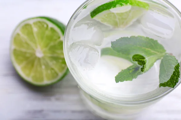 Fresh cocktail with ice, mint and lime on white wooden table background — Stock Photo, Image