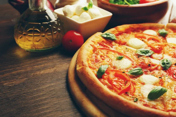 玛格丽塔披萨与西红柿、 橄榄油和意大利干酪木制背景 — 图库照片