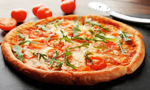 Margherita pizza com faca e tomate no prato de ardósia — Fotografia de Stock