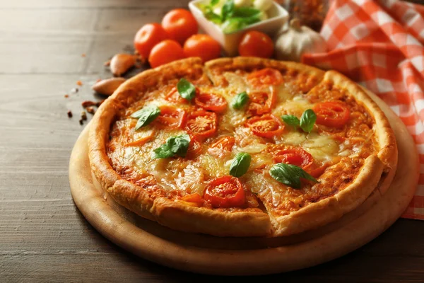 Pizza Margherita con especias y tomates sobre fondo de madera —  Fotos de Stock
