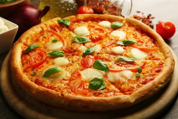 Margherita pizza with tomatoes and spices on wooden background — Stock Photo, Image