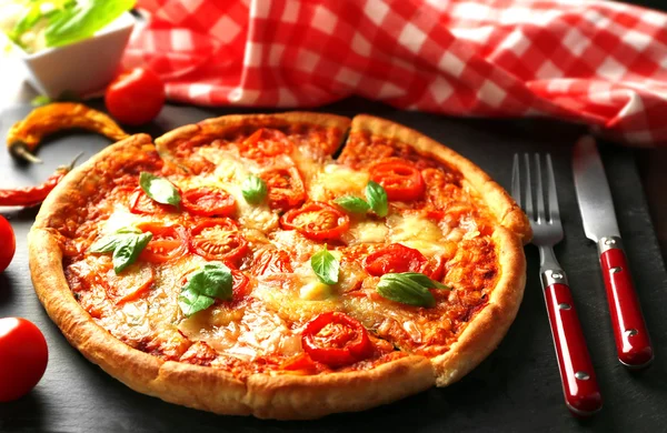 Pizza Margherita con utensilios y verduras en plato de pizarra —  Fotos de Stock