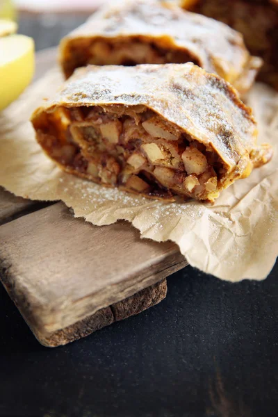 Sneetjes strudel met appels, walnoten en rozijnen op perkament — Stockfoto