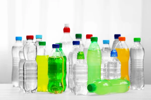 Bottles of water and soda drinks on the white table. — Stock Photo, Image