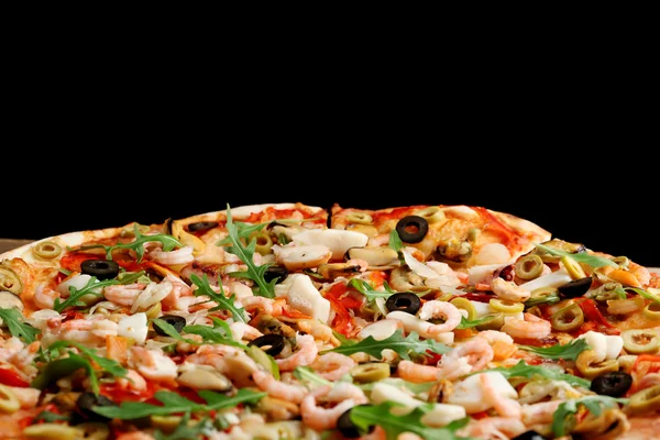 Pizza con mariscos, pimiento rojo y aceitunas sobre fondo negro, de cerca —  Fotos de Stock