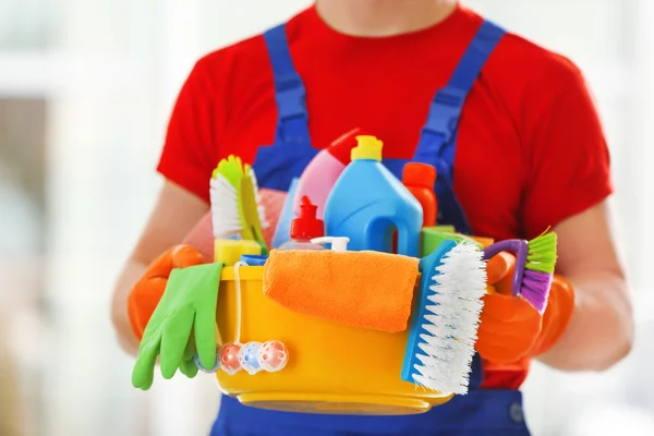 Jovem zelador segurando produtos de limpeza — Fotografia de Stock