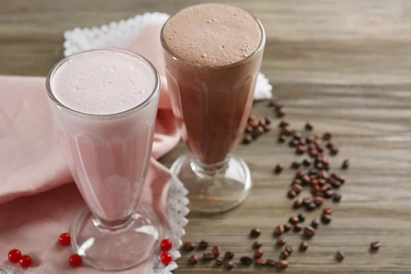 Szemüveg, a csokoládé és a gyümölcs tejes turmixokat és szemes kávé, fából készült háttér — Stock Fotó