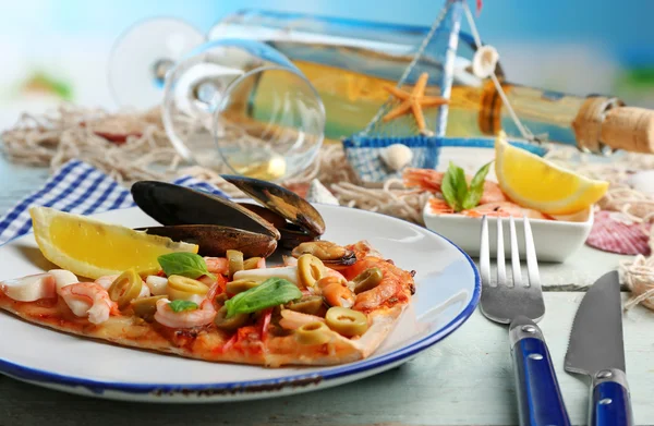 해산물, 고추, 녹색 올리브와 나무 테이블에 와인 병 피자 슬라이스 — 스톡 사진