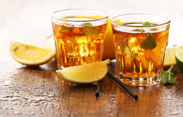 Dos vasos de té helado con limón sobre fondo de madera — Foto de Stock