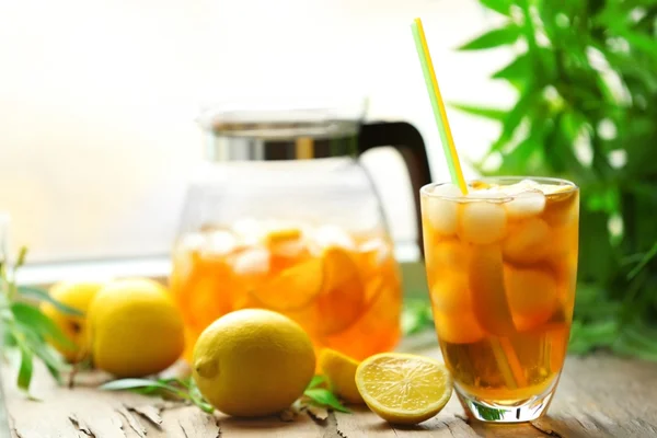 Vaso y frasco de té helado con limón en un alféizar de la ventana —  Fotos de Stock