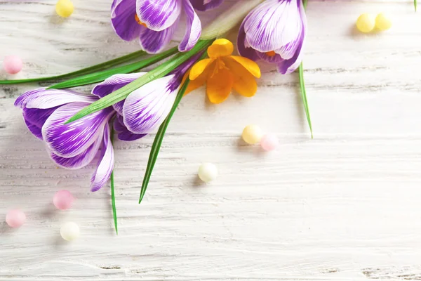 Hermosas flores de cocodrilo con cuentas sobre fondo de madera —  Fotos de Stock