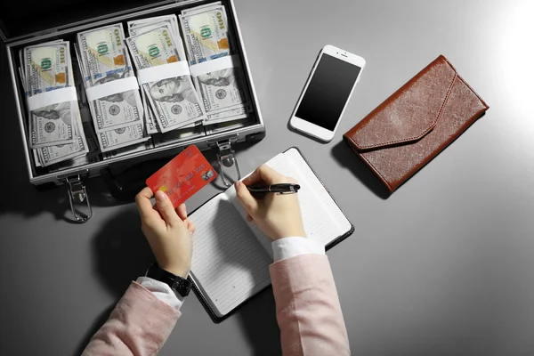 Empresario escribiendo en cuaderno con caja de dinero —  Fotos de Stock