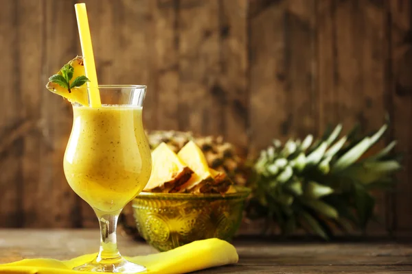 Pineapple smoothie in cocktail glass on wooden background — Stock Photo, Image