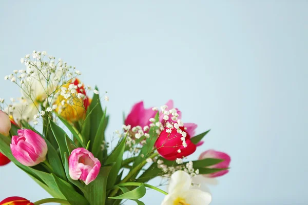 Ramo de hermosos tulipanes coloridos sobre fondo de pared azul claro —  Fotos de Stock