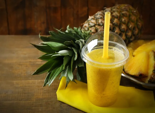 Ahşap arka plan üzerinde plastik bardak ananas smoothie — Stok fotoğraf