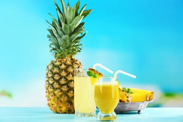 Ananas suyu ve güler yüzlü üzerinde mavi arka plan bulanık kokteyl gözlük — Stok fotoğraf