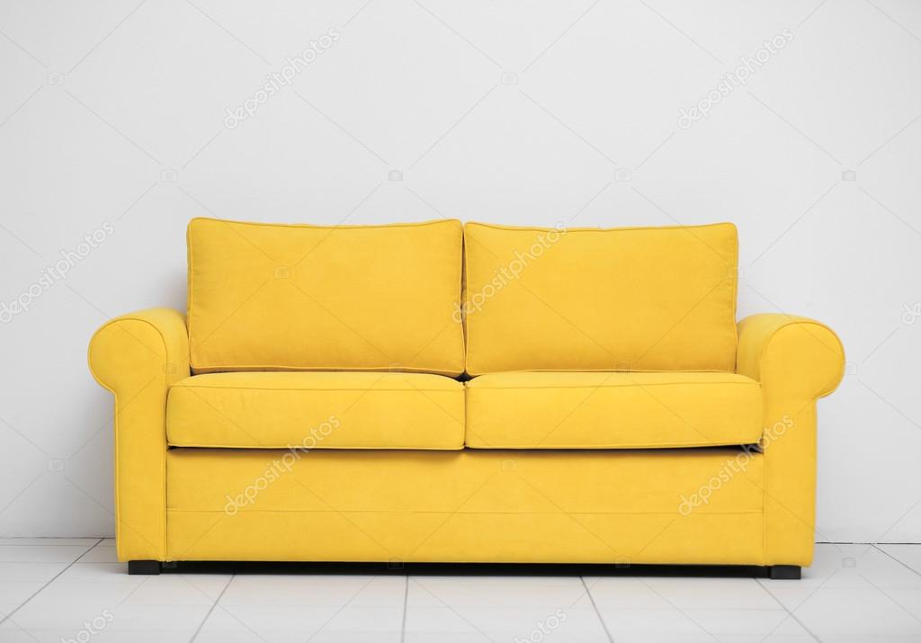 Yellow sofa against wall Stock Photo by ©belchonock 105084612