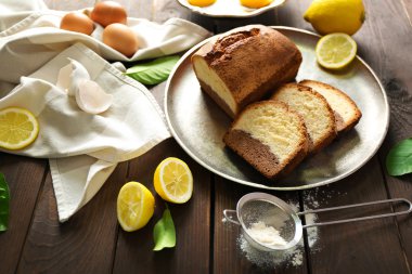 Lezzetli tatlı pasta ekmek içinde ahşap masa portre üzerinde limon ile metal tepsi