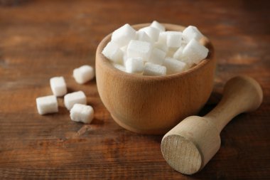 Lump & şeker ve masanın üzerinde çekiç ile ahşap kase