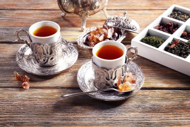 Siyah çay bardak ile gümüş cam tutucu ahşap tablo