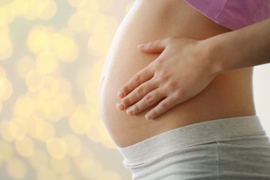 Bulanık glitter zemin üzerine hamile kadın