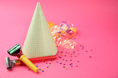 Serpantin flama ve pembe bir arka plan gürültü makineleri ile noktalı doğum günü şapkası