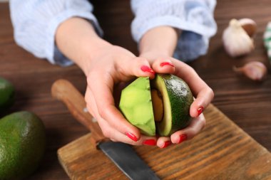 Yarıya avokado holding eller
